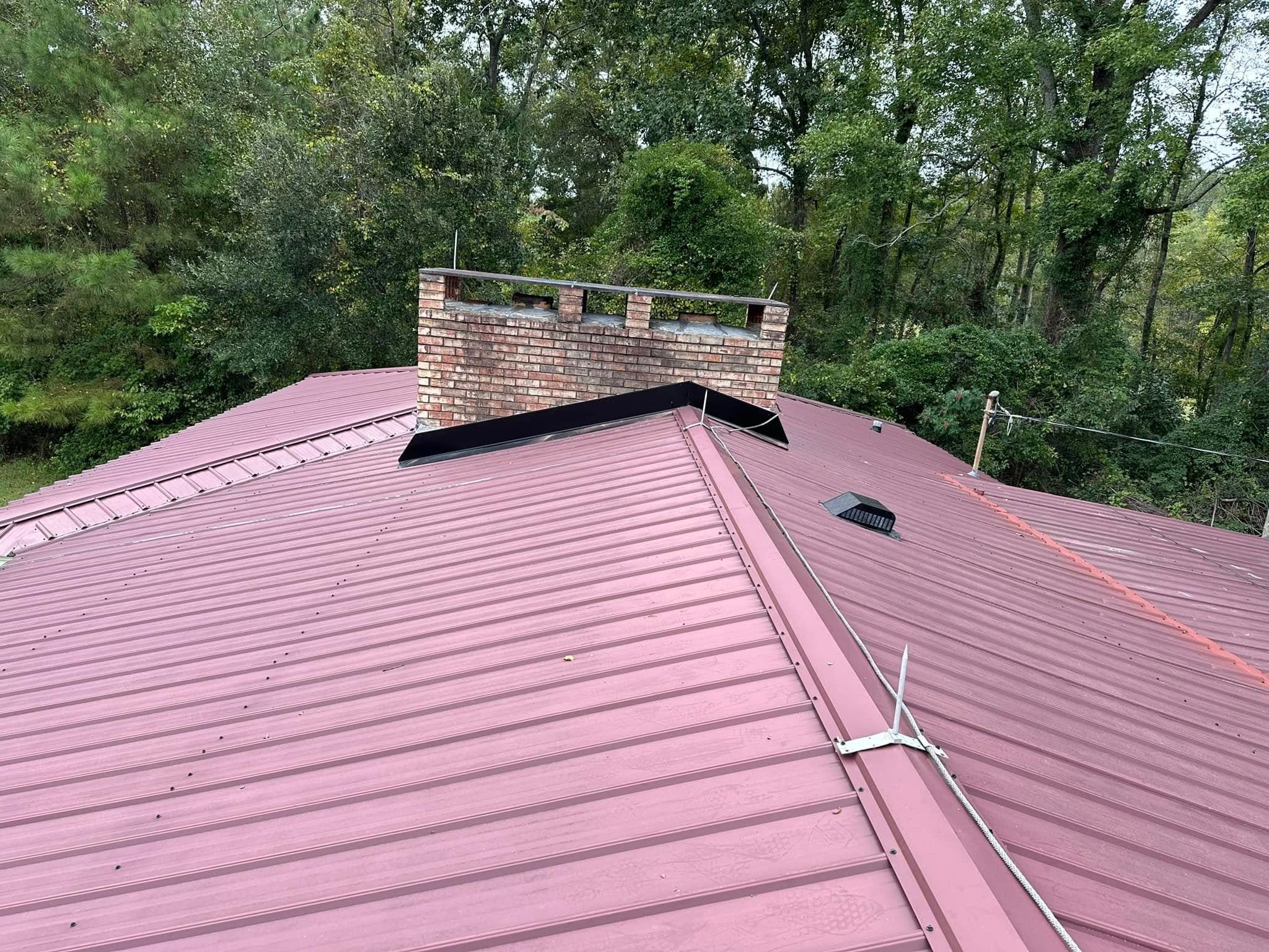 Completed metal roof with new black chimney flashing